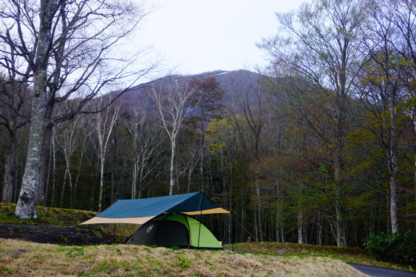 岩手山の雄大な存在感を背景に、自然と一体化したテント設営の瞬間